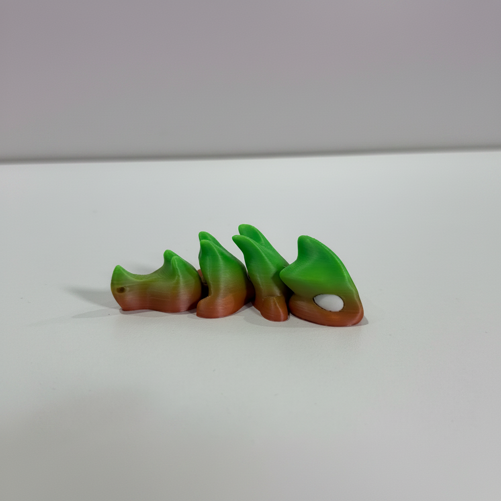 Hatchling — green-to-coral colorway, four articulated segments with curved fins